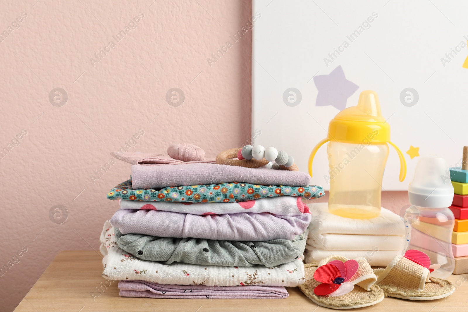 Photo of Baby clothes and accessories on wooden table