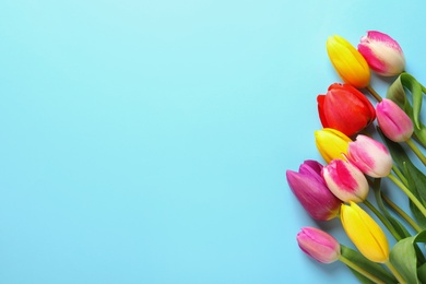 Photo of Beautiful spring tulip flowers on color background, top view. Space for text