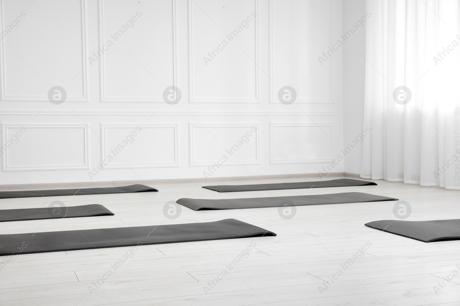 Photo of Spacious yoga studio with exercise mats. Space for text