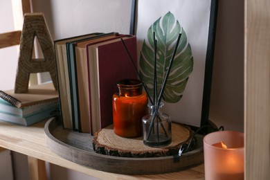 Stylish tray with different interior elements on wooden shelf