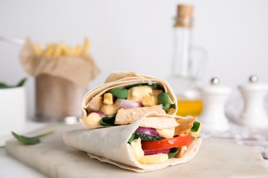 Photo of Delicious shawarmas with chicken and fresh vegetables on white table, closeup