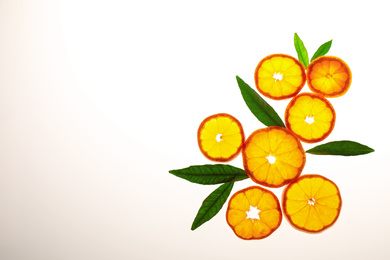 Photo of Slices of fresh ripe tangerines and leaves isolated on white, top view. Citrus fruit