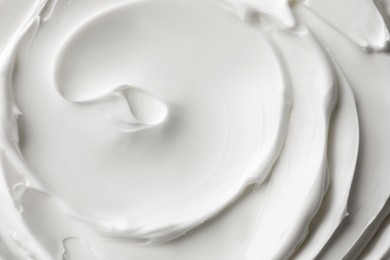 Photo of Texture of white face cream as background, top view