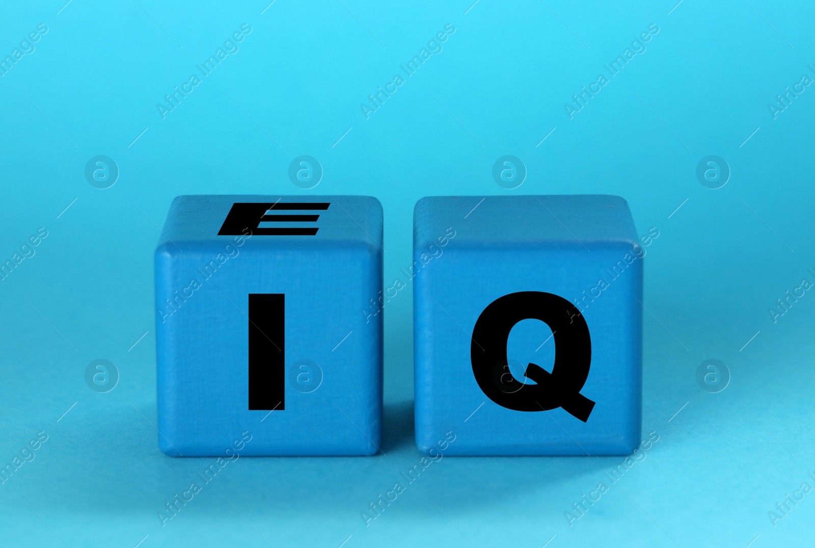 Photo of Cubes with abbreviation IQ on light blue background