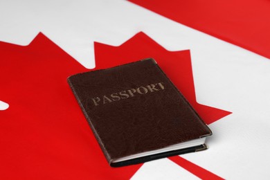 Photo of Immigration to Canada. Passport on flag, closeup
