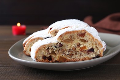 Photo of Traditional Christmas Stollen with icing sugar on wooden table