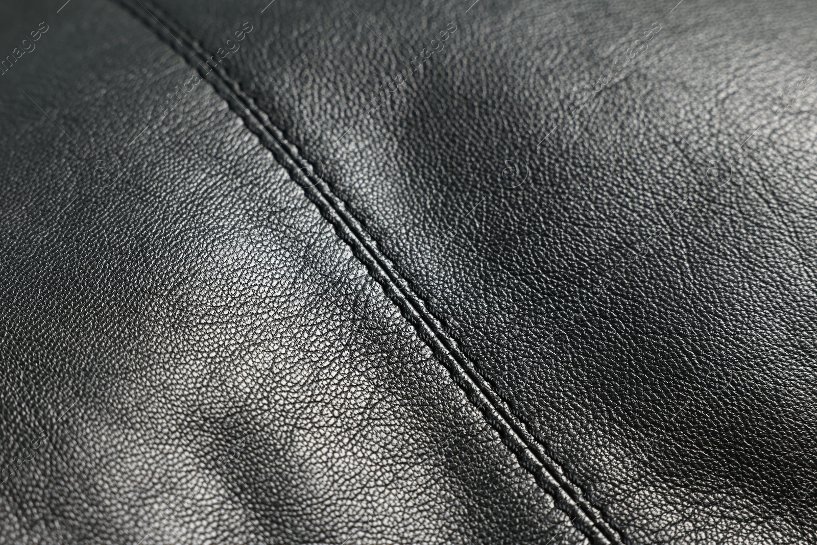 Photo of Black natural leather with seams as background, closeup view