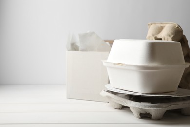 Photo of Heap of waste paper on white wooden table, space for text