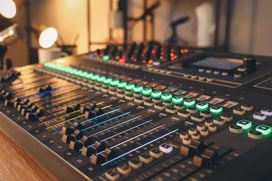 Professional mixing console on table in modern radio studio, closeup