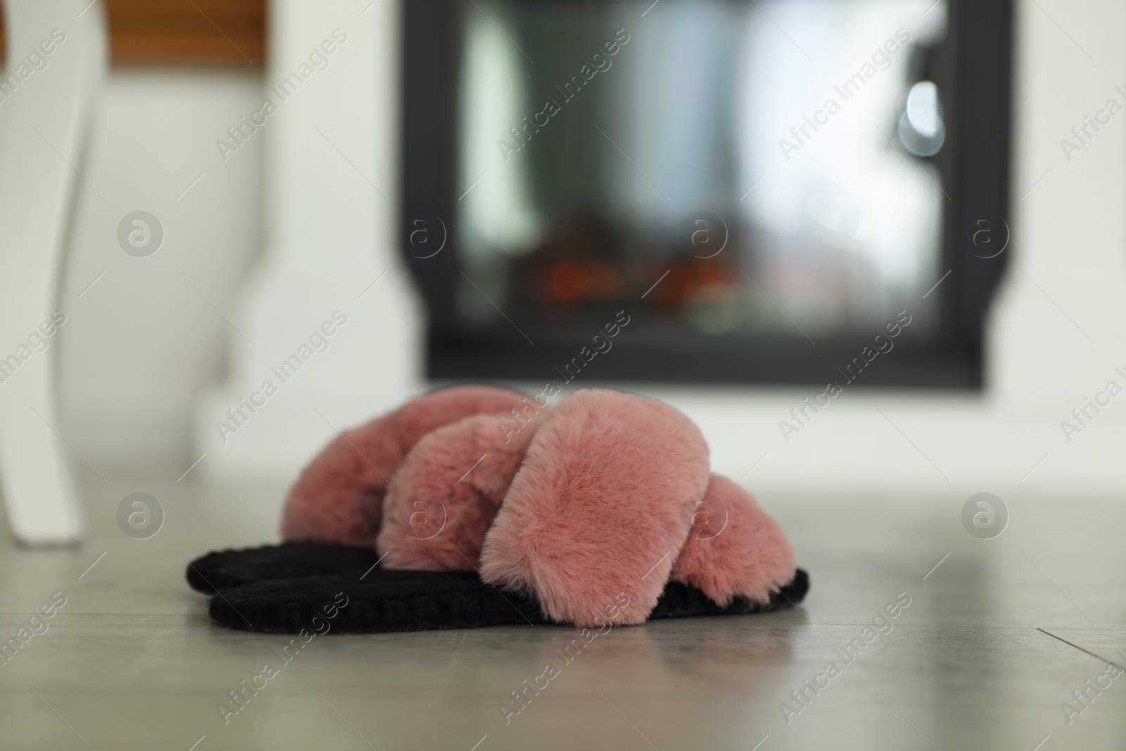 Photo of Fluffy women's slippers on floor in room