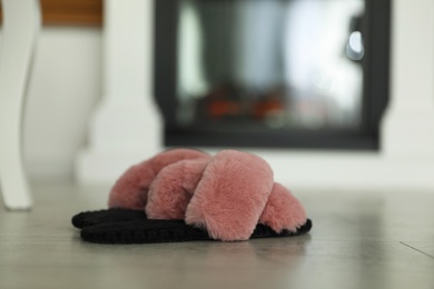 Photo of Fluffy women's slippers on floor in room