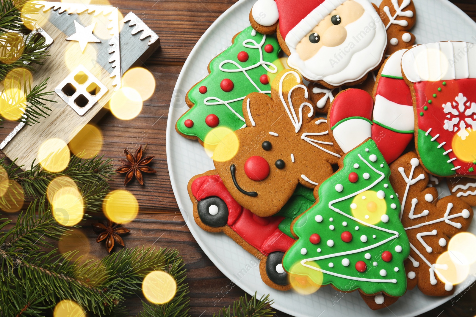 Photo of Different tasty Christmas cookies and festive decor on wooden table, flat lay