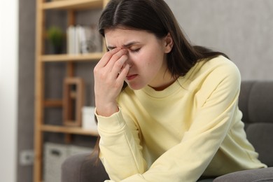 Overwhelmed woman suffering from headache at home