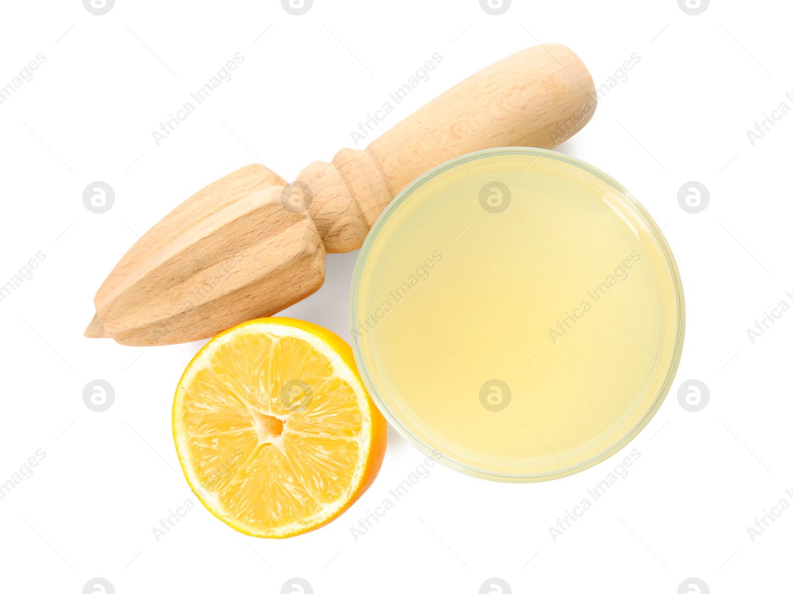 Photo of Freshly squeezed juice, half of lemon and reamer on white background, top view