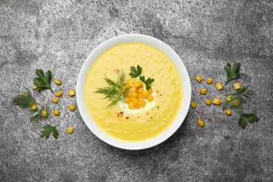 Delicious creamy corn soup served on grey table, flat lay