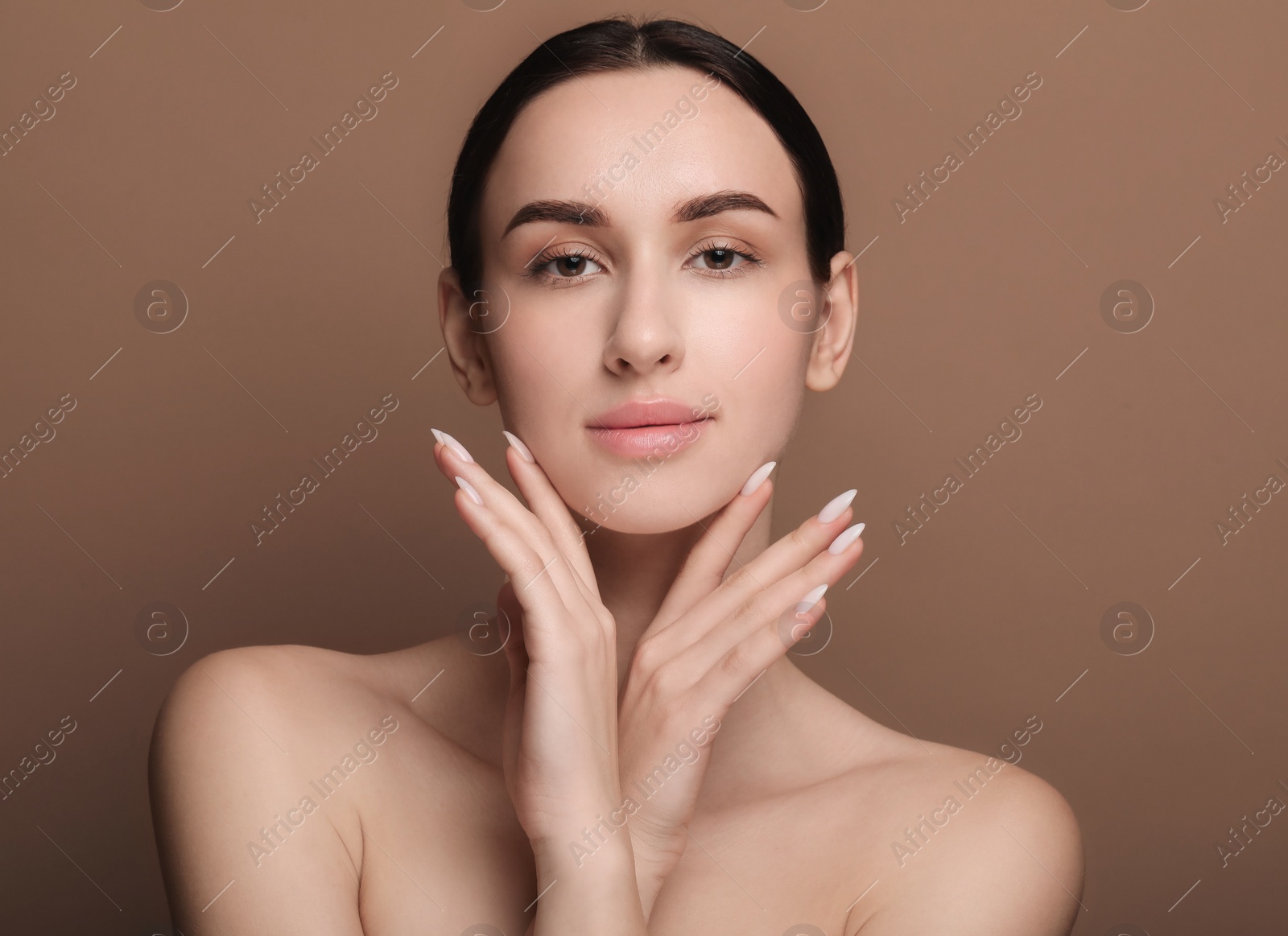 Photo of Portrait of beautiful young woman on brown background