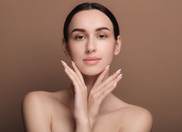 Portrait of beautiful young woman on brown background