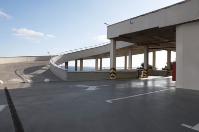 Photo of Empty outdoor car parking lot with ramp on sunny day