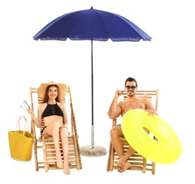 Photo of Young couple with beach accessories on sun loungers against white background