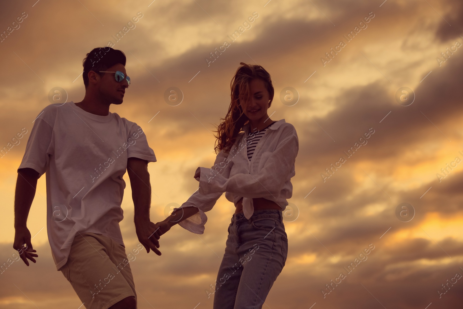 Photo of Happy couple dancing outdoors during beautiful sunset