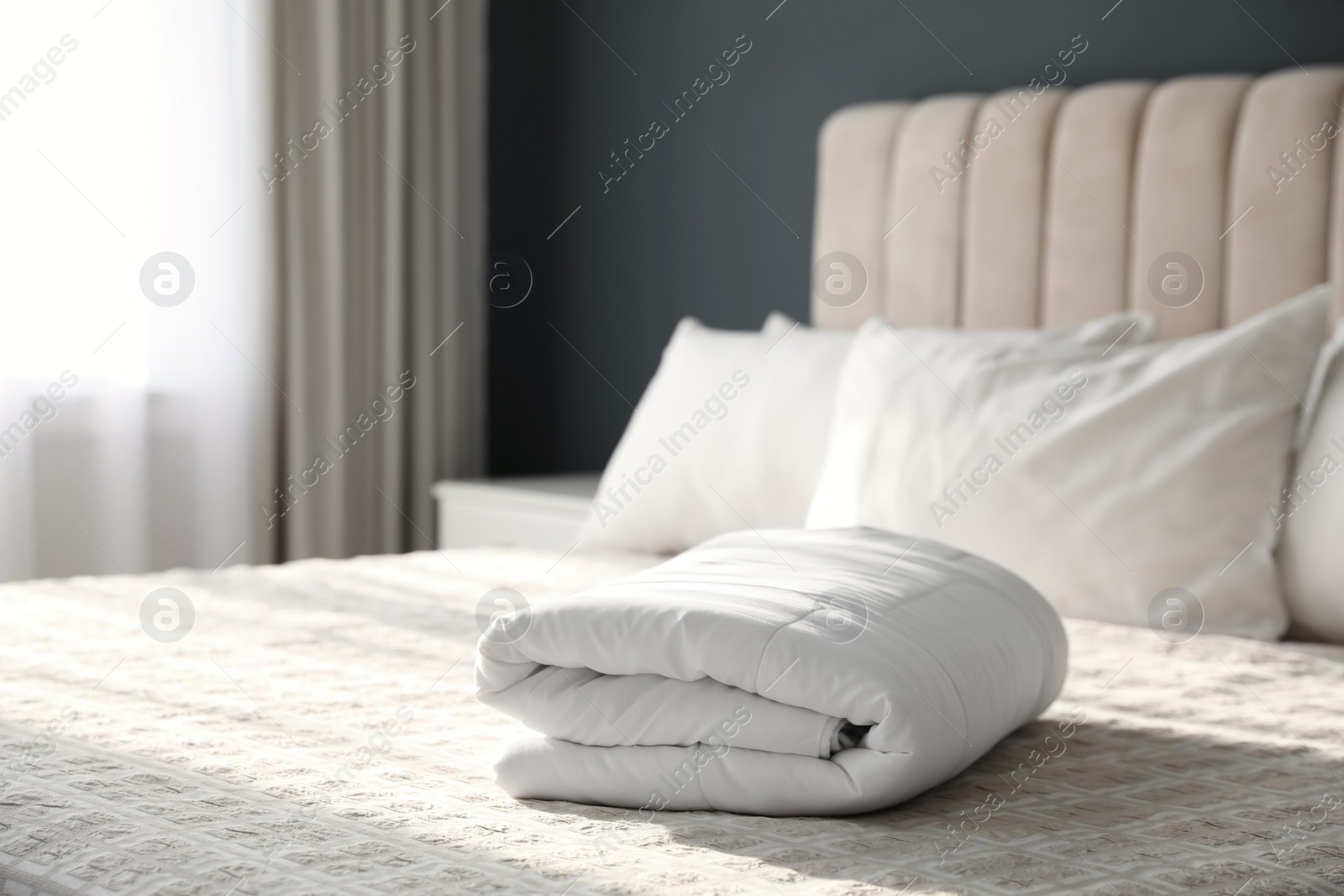 Photo of Folded clean blanket on bed in room
