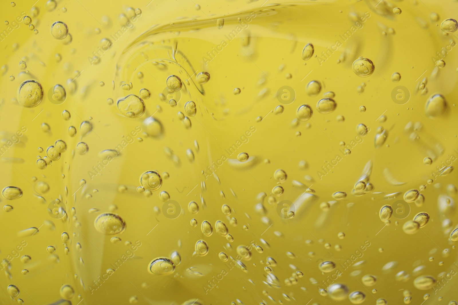 Photo of Pure transparent cosmetic gel on yellow background, closeup