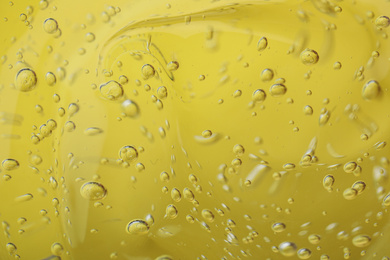 Pure transparent cosmetic gel on yellow background, closeup