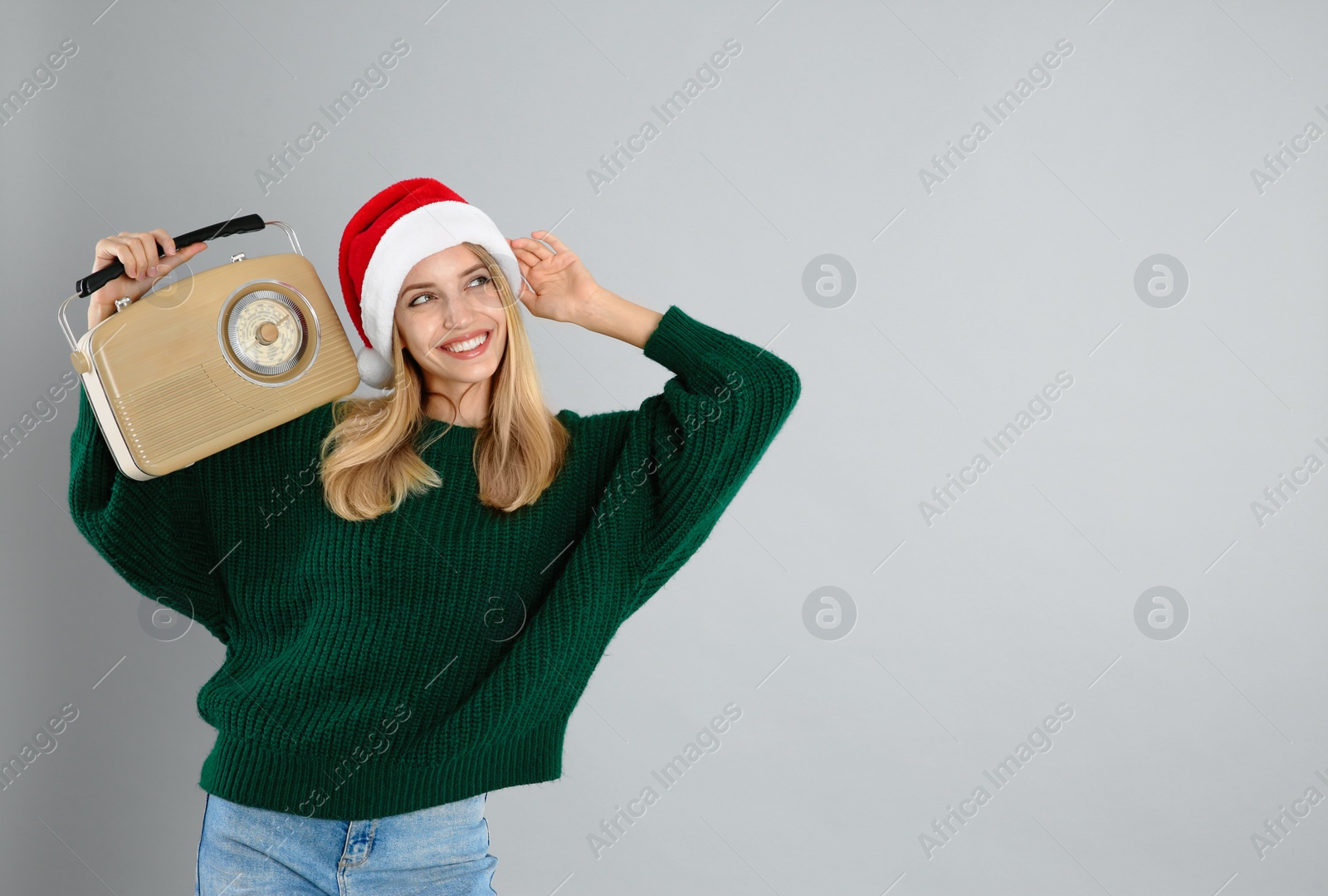 Photo of Happy woman with vintage radio on grey background, space for text. Christmas music