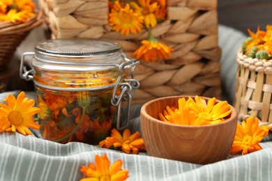 Many beautiful fresh calendula flowers on table