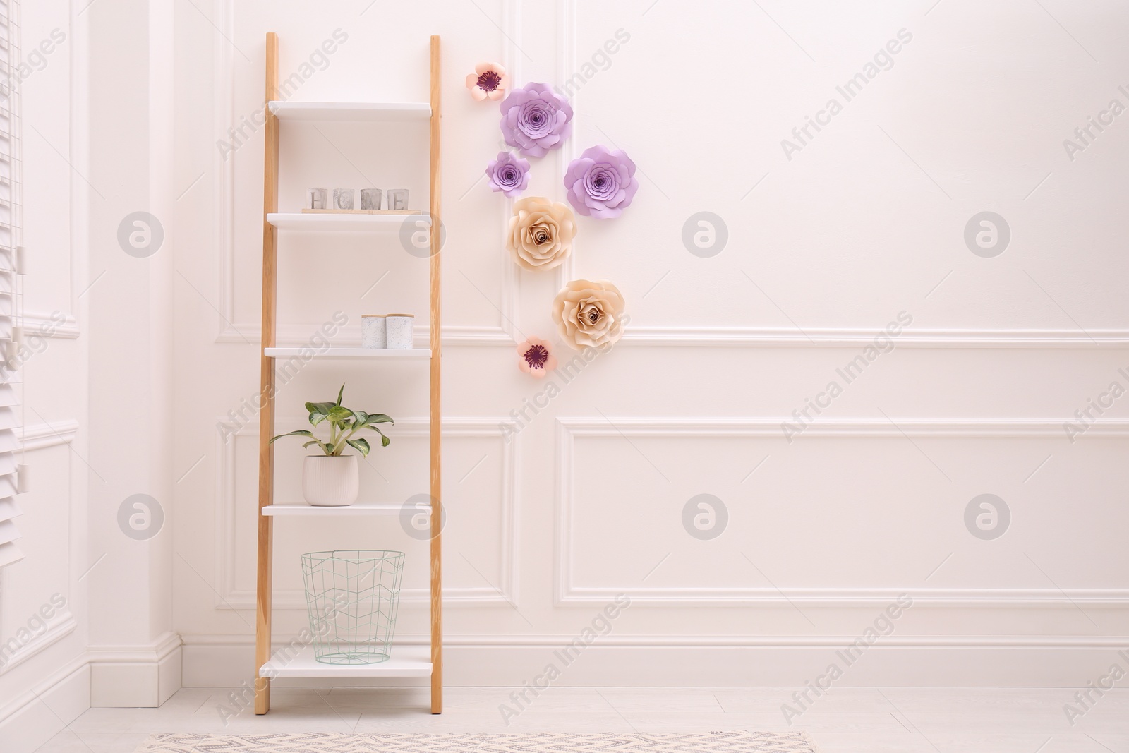 Photo of Shelving unit near wall with floral decor in room, space for text. Interior design