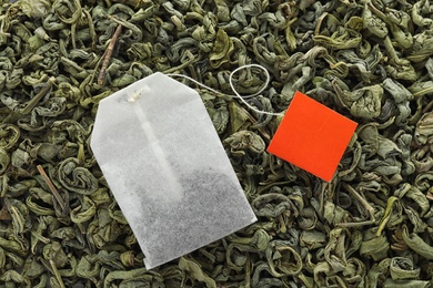 Photo of Tea bag on dry leaves, top view. Mockup for design