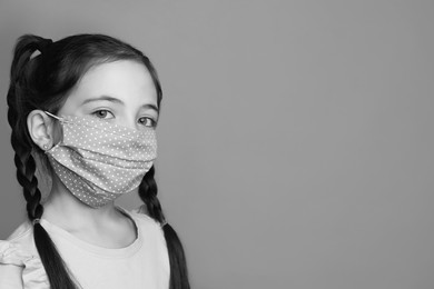 Image of Girl wearing medical face mask on light background, space for text. Black and white photography