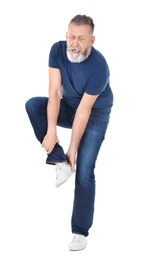 Man suffering from leg pain on white background