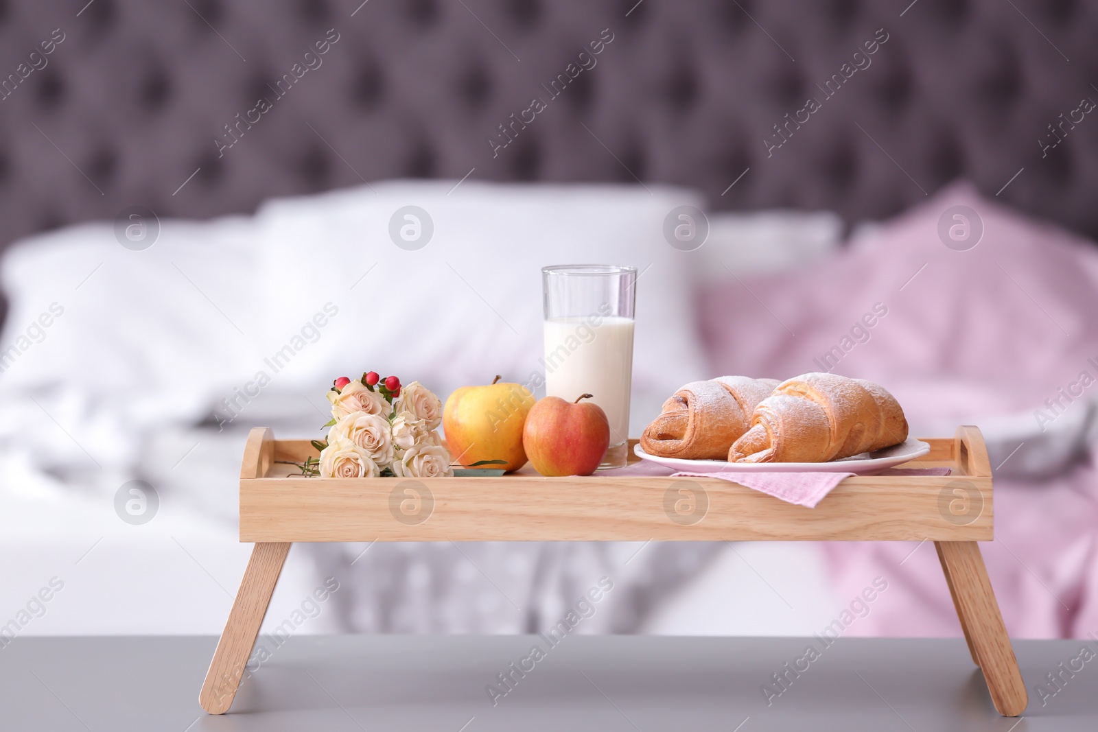 Photo of Tray with delicious croissants, milk and apples on table