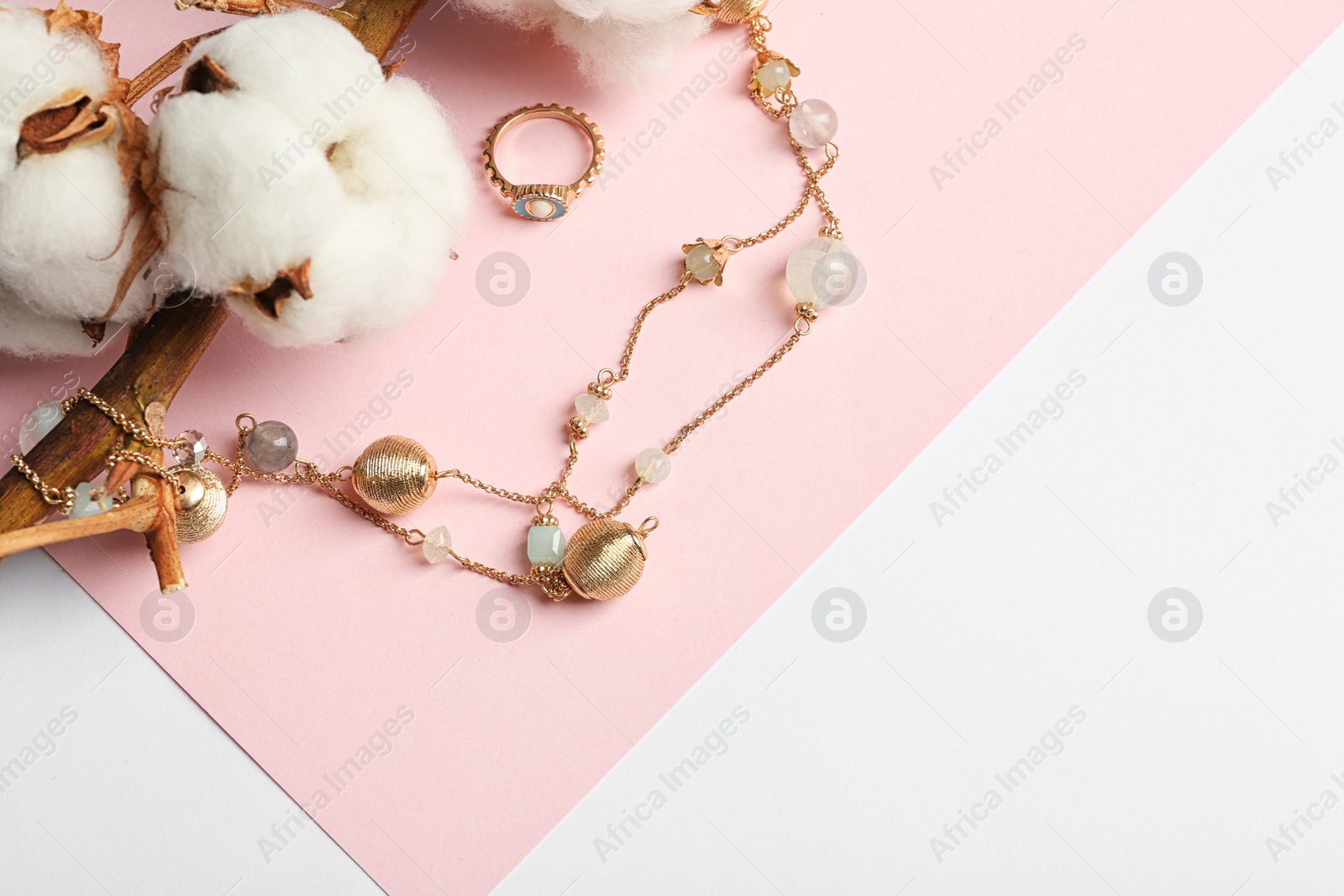 Photo of Elegant jewelry and cotton flowers on color background. Space for text