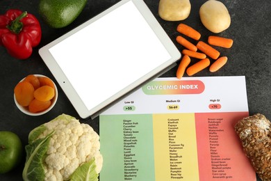 Photo of Paper with information about glycemic index, blank tablet and different products on grey table, flat lay