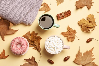 Photo of Flat lay composition with hot cozy drinks and autumn leaves on color background
