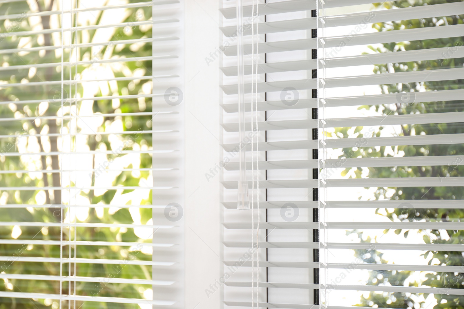 Photo of Open white horizontal window blinds, closeup view