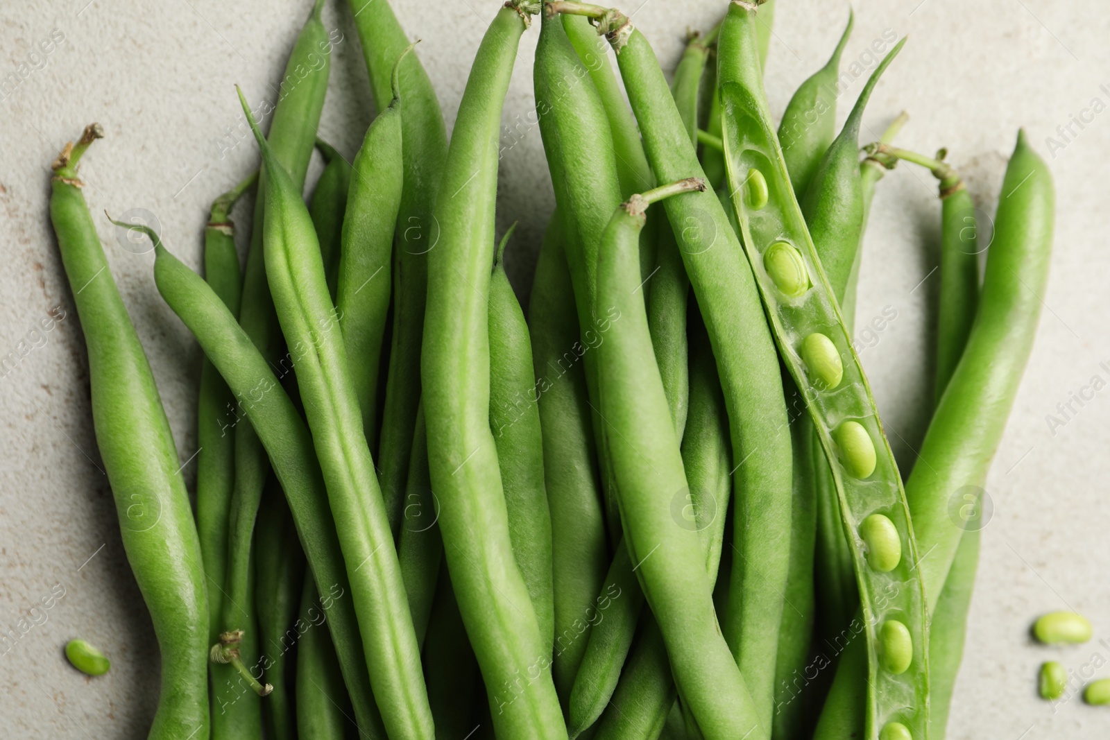 Photo of Fresh green beans on light grey table, flat lay