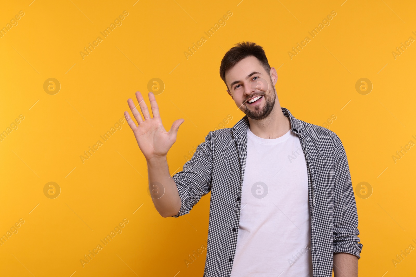 Photo of Man giving high five on yellow background. Space for text