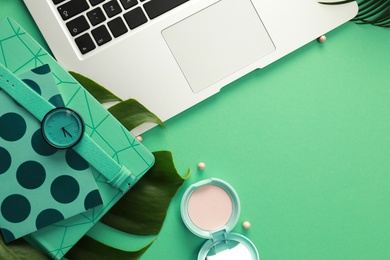 Flat lay composition with laptop on green background. Fashion blogger
