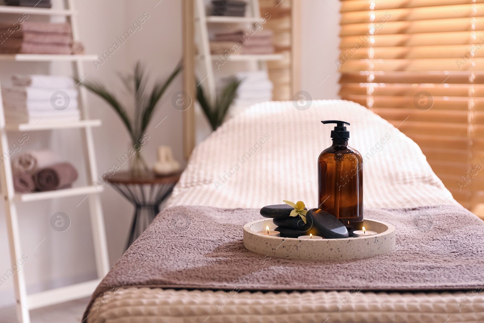 Photo of Beautiful spa accessories on massage table in room