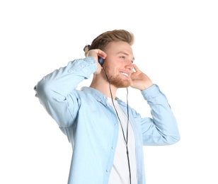 Photo of Handsome young man listening to music with headphones on white background