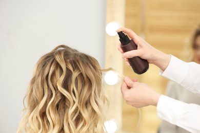 Photo of Hair styling. Professional hairdresser working with client indoors, closeup