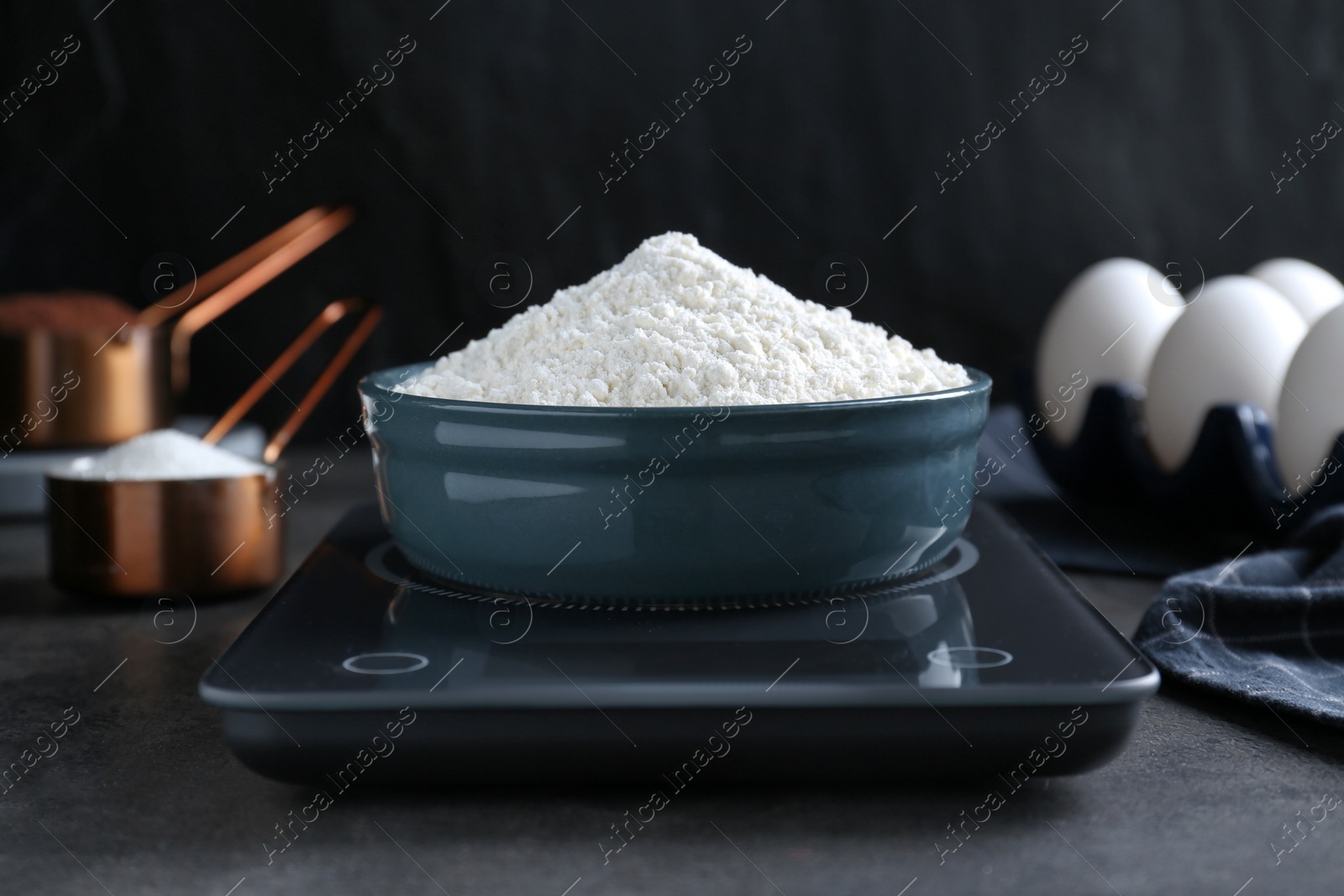 Photo of Electronic scales with flour on black table