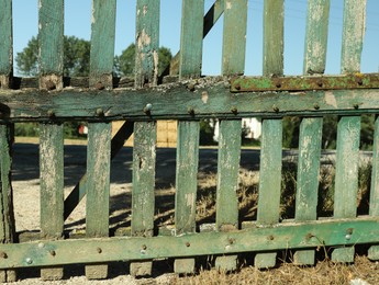 Photo of Old green wooden fence on sunny day