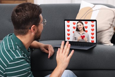 Image of Long distance love. Man having video chat with his girlfriend via laptop at home