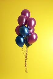 Photo of Bunch of bright balloons on color background