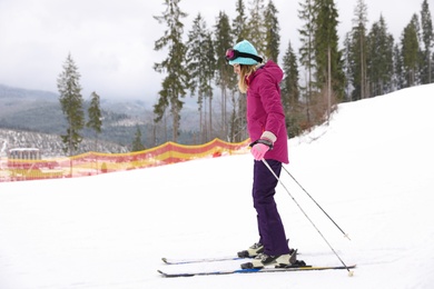 Photo of Female skier on slope at resort. Winter vacation