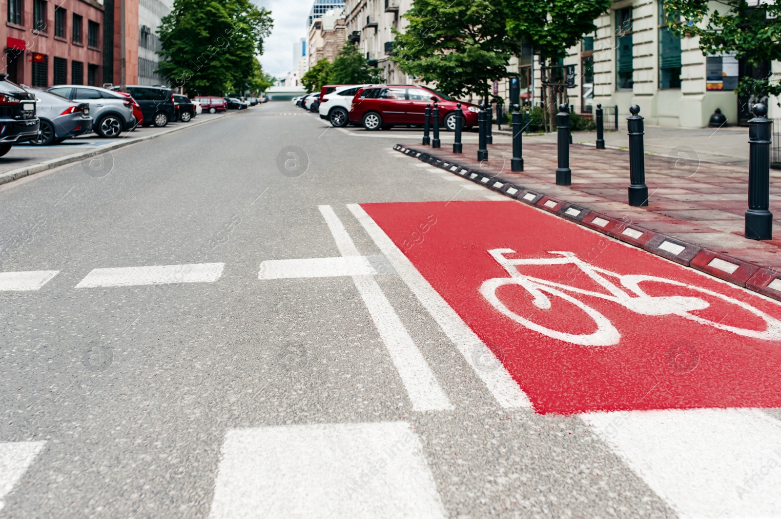 Photo of Red bike lane with painted white bicycle sign on city street